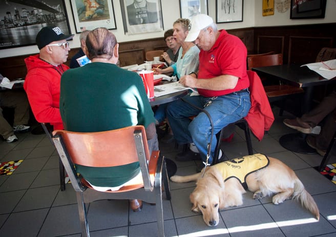 Friends enjoy crossword puzzles and bagels with Glyn Judson (right) and his golden retriever guide dog Fred at New York Bagel and Deli on Wilshire Boulevard on Monday morning. (Brandon Wise brandonw@www.smdp.com)