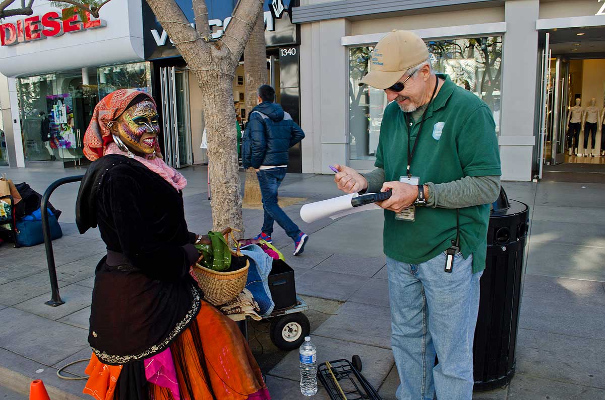 MAKING ROUNDS: Stephen Bradford checks in on one of the street performers he oversees on the Third Street Promenade. (Paul Alvarez Jr. editor@www.smdp.com)