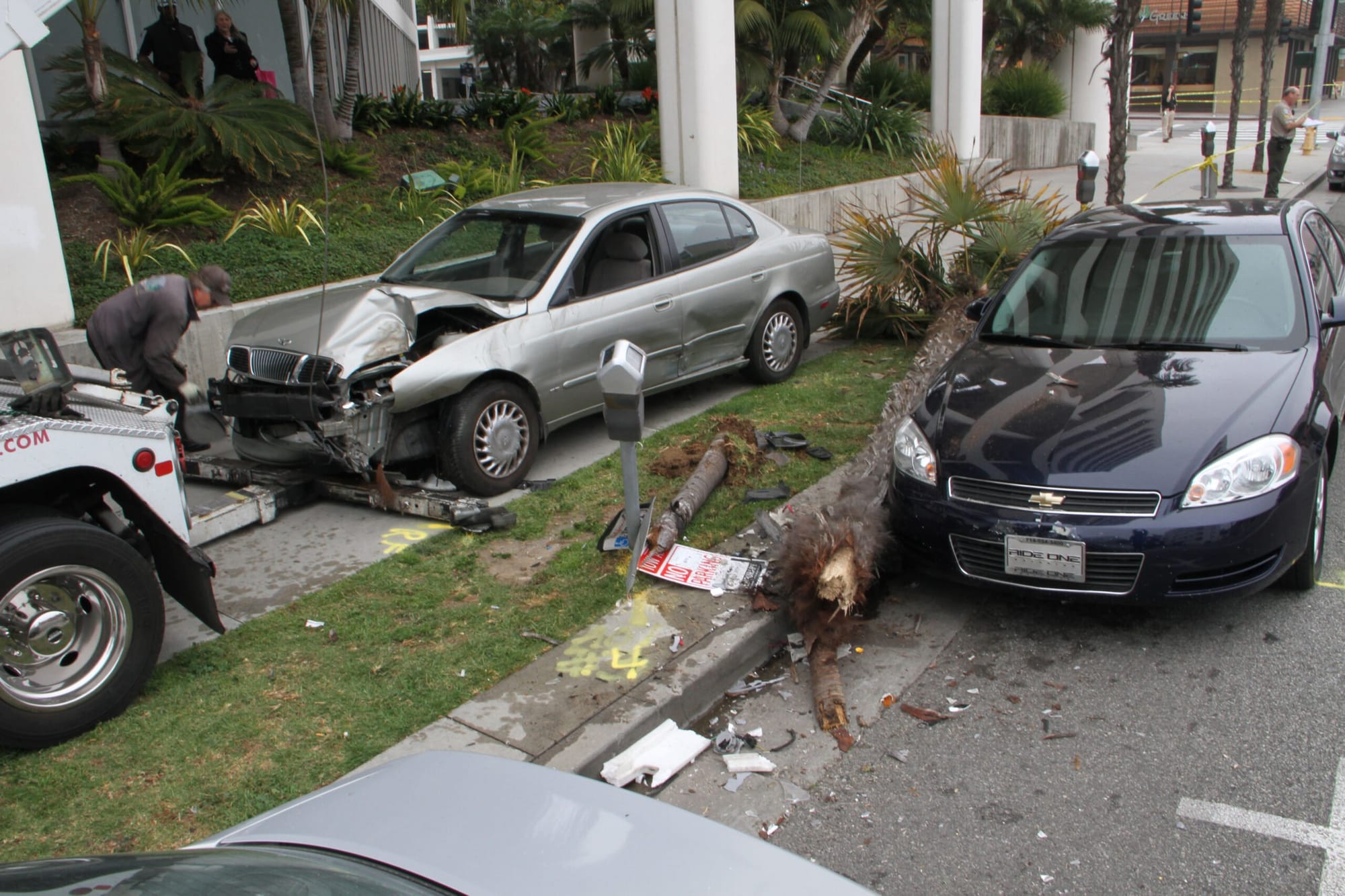 A tow-truck driver tries to hook up a car Friday that was involved in a car accident at the corner of Second Street and Arizona Avenue. Police said the 89-year-old driver ran a red light at the intersection, collided with another car and then proceeded onto the Second Street sidewalk, striking a female pedestrian, who held onto the hood for several feet before the car hit a tree and stopped. The woman, in her 20s, was conscious but was taken to a hospital for treatment. Second Street and Arizona Avenue were closed for a couple of blocks from roughly 2 p.m. to 5 p.m. The site of the crash and age of the driver reminded some bystanders of the deadly Farmers' Market crash of 2003 in which 10 people were killed.