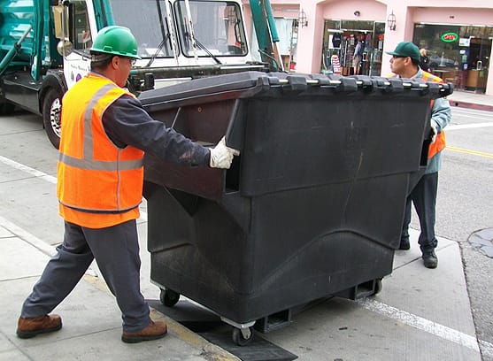 Garbage men use rubber ramps to move more easily a dumpster on Montana Avenue. The ramps were made from recycled tires. (Photo courtesy city of Santa Monica)