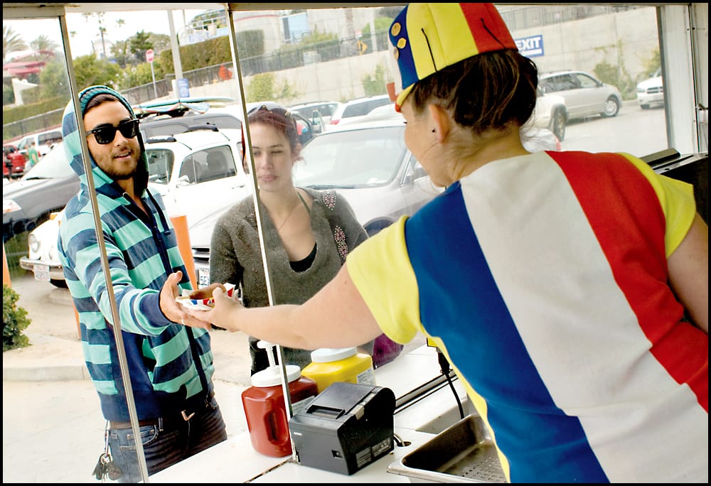 A Hot Dog on a Stick employee serves a corndog at the original location on Ocean Front Walk. (File photo)
