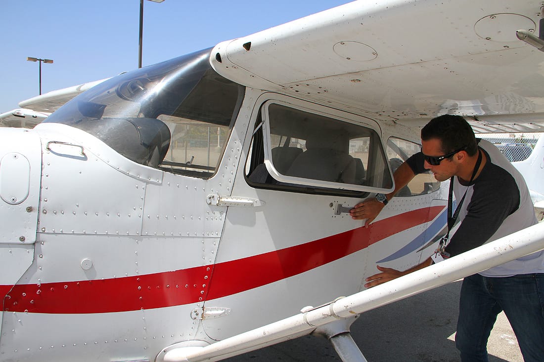 PREFLIGHT: Justice Aviation instructor Jordan LaMotte inspects one of the company's planes. (Photo by Daniel Archuleta)