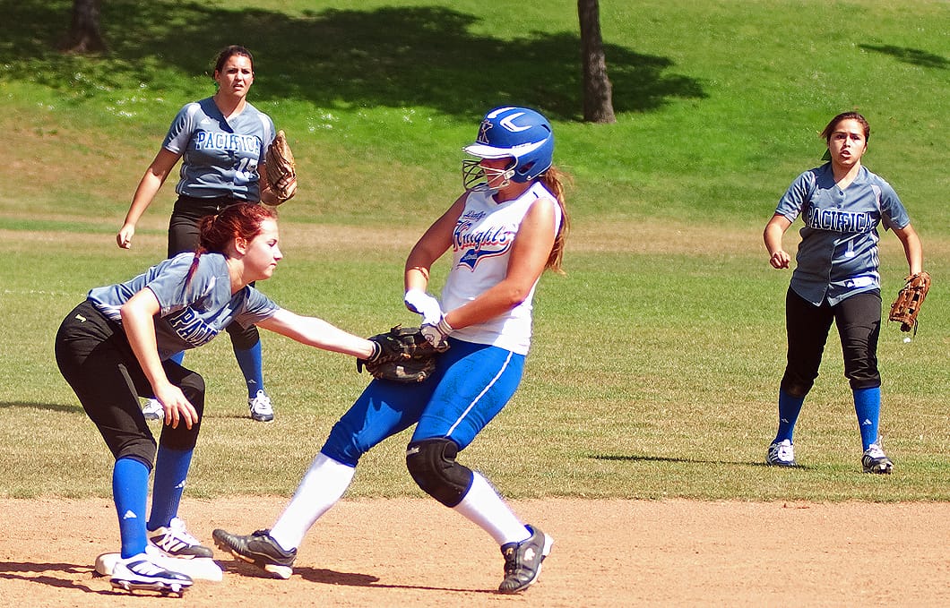 SHE'S OUT: Pacifica Christian's Spencer Dolan (left) tags out Academy for Academic Excellence's Alyssa Fredrick while teammates watch on Tuesday at Clover Park. Pacifica Christian went on to lose the second round playoff game, 12-0. (Photo by Morgan Genser)