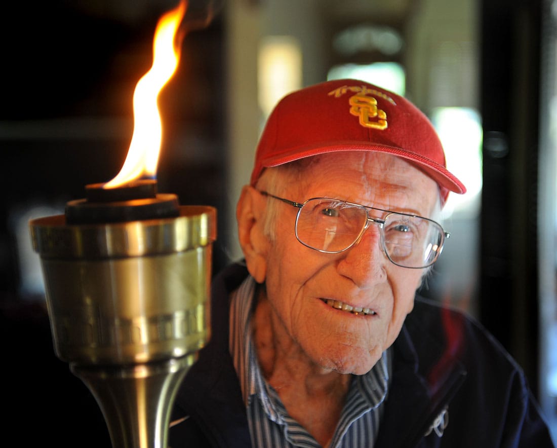 Louis Zamperini, 96, at his Hollywood home. The flame still burns in him as he holds the olympic torch he carried at the 1984 Olympic Games. (Photo by Brad Graverson)