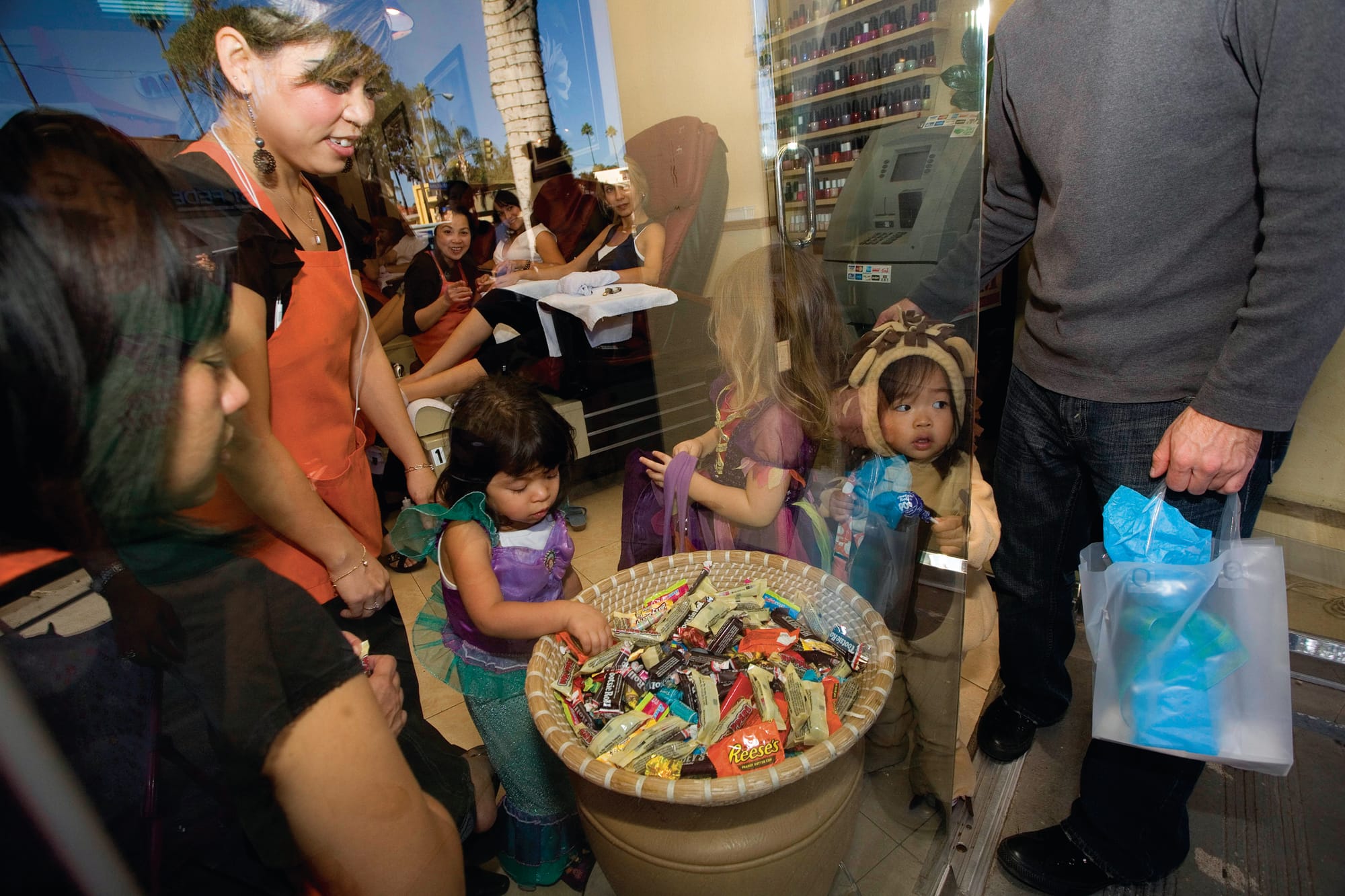 Trick-or-treaters grab candy at a nail salon on Montana Avenue. (File photo)