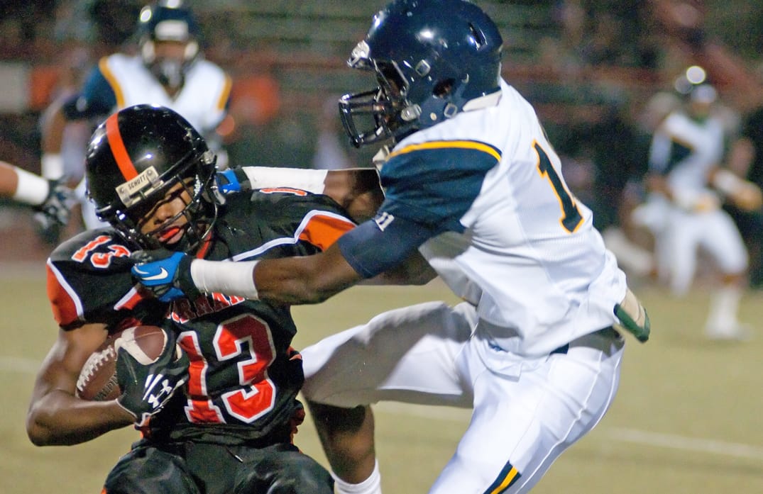 Samohi's Ahmad Clayton (right) tackles Beverly Hills' Damiyon Brown on Friday on the road. (Morgan Genser editor@www.smdp.com)