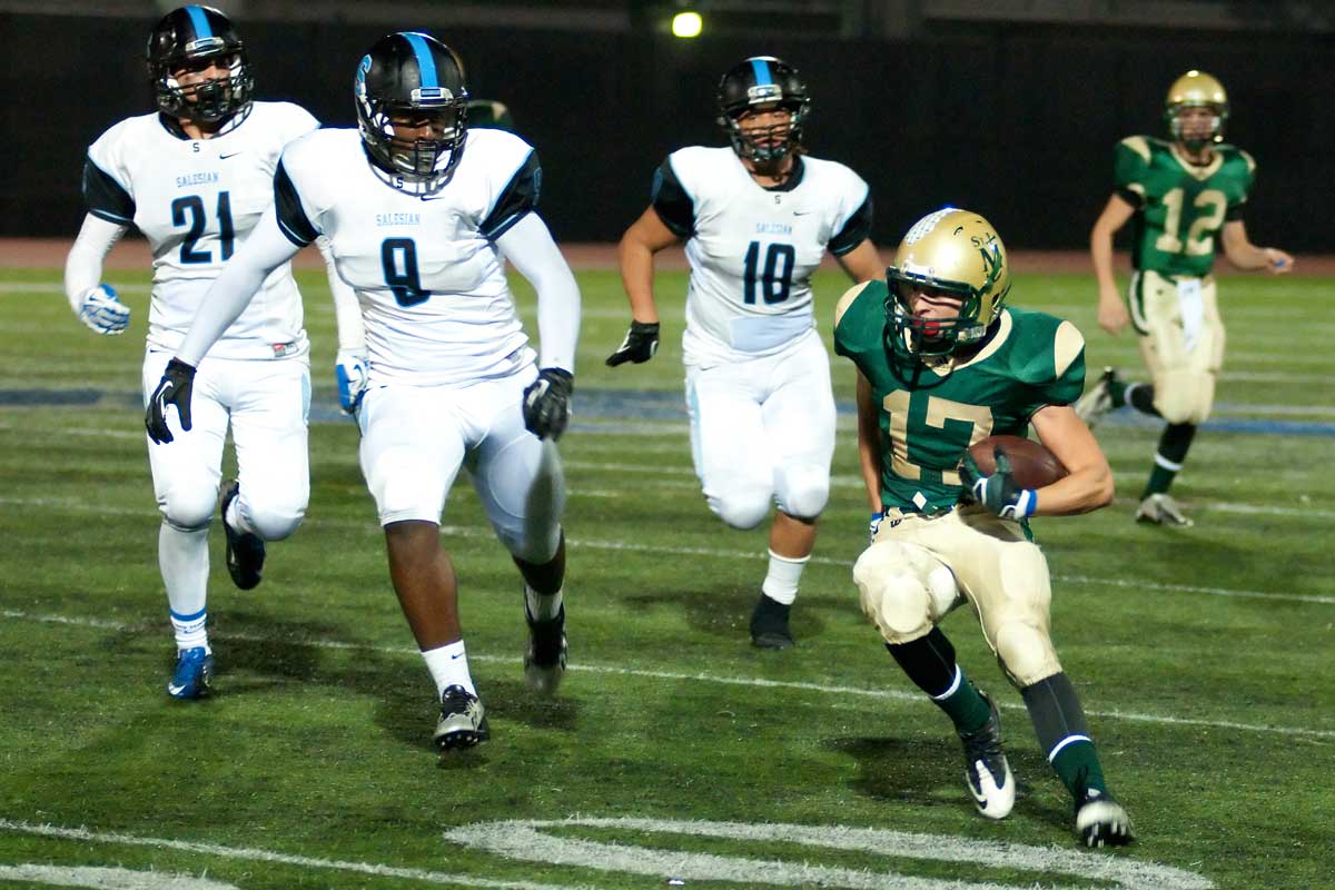 St. Monica's David Araujo runs for a gain against Salesian on Friday. St. Monica lost, 42-3. (Morgan Genser)