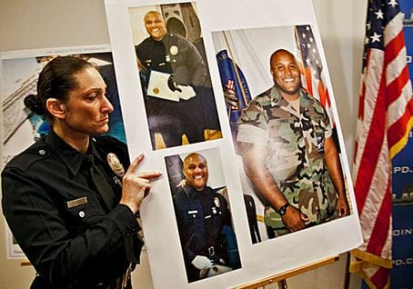 An LAPD officer holds up photos of suspected cop killer  Christopher Dorner. (Photo courtesy Google Images)